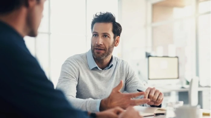 Führungskraft gibt Mitarbeiter konstruktives Feedback im Büro